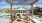 a couple of women sitting on a deck by a pool