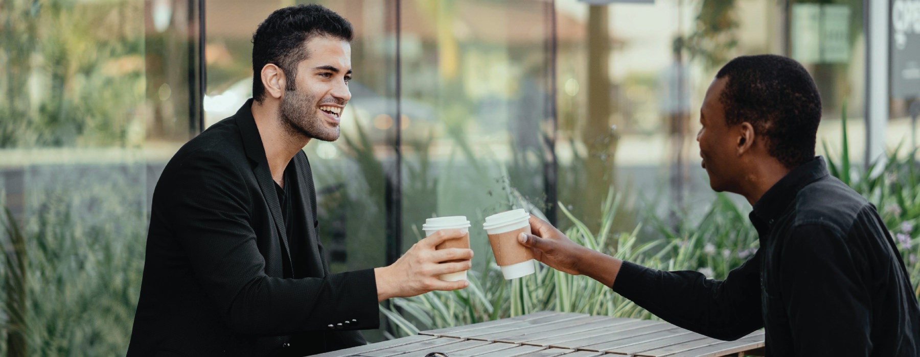 a couple of men sitting at a table and talking